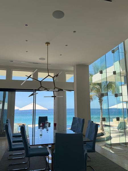 Oceanfront villa dining room with glass walls in Los Cabos