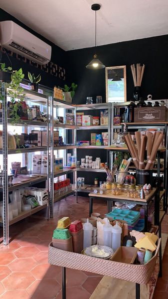 Small pantry shop with metal shelves of dry goods, spices, oils and kitchen utensils