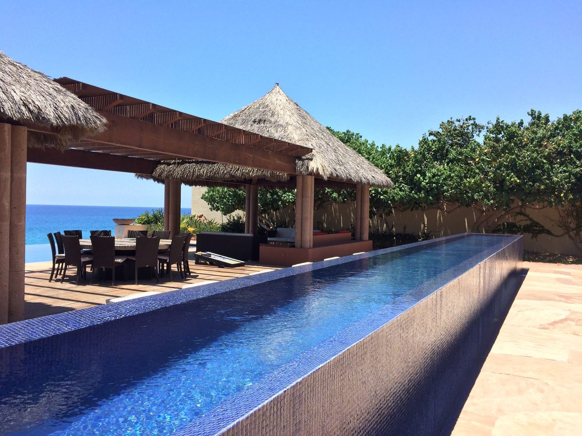 Infinity pool and palapas at an oceanfront villa in Los Cabos